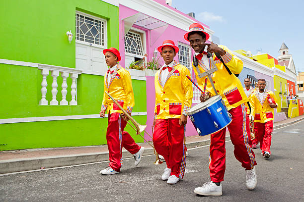 Cape Town Minstrels Carnival Cape Town, South Africa - January, 2nd 2011: Minstrels dressed up for the Cape Town Carnival, carrying their musical instruments, trumpets and drum. Cape Town celebrates this event as (The second New Year), a traditional festival for the Cape Coloured community. malay quarter photos stock pictures, royalty-free photos & images