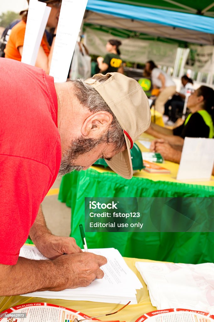 Man registering at Disaster emergency awareness fair Magnolia, Texas, USA - May 21, 2011: CERT, Community Emergency Response Team, hosted an emergency awareness fair prior to the hurricane season.   Team members shared information and answered questions asked by those attending.  Man is registering for CERT training.  Texans were reminded of the dangers of hurricanes and fires and to Make a Plan and Make a Kit. A Helping Hand Stock Photo