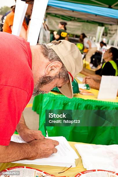 Man Registering At Disaster Emergency Awareness Fair Stock Photo - Download Image Now