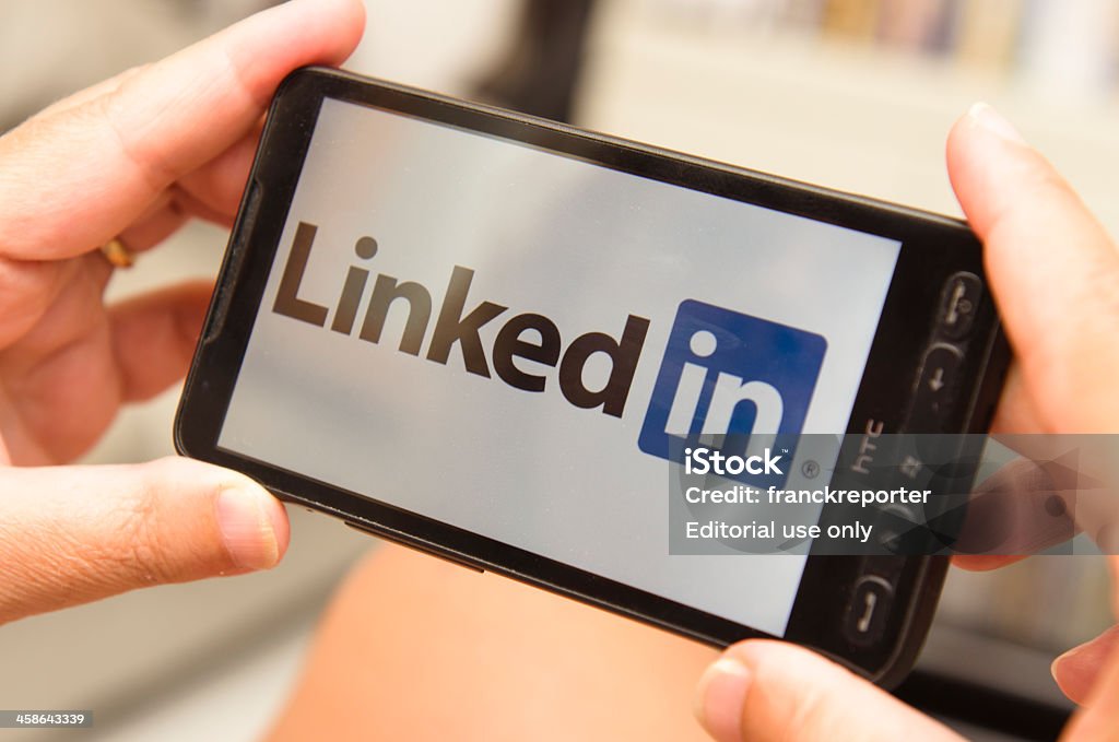 Frau, die ein smartphone mit linkedin logo - Lizenzfrei LinkedIn Stock-Foto
