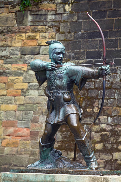 Robin Hood "Nottingham, United Kingdom - July, 23th 2011: Bronze statue of famous Robin Hood in front of castle in Nottingham. Statue was given and donated by EF Clay Esquire on 28th June 1949. Statue and castle are one of most visited sight seeing attractions in Nottingham." nottingham stock pictures, royalty-free photos & images