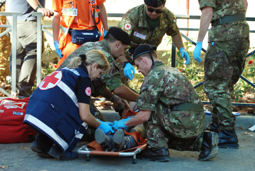 Asti, Italy - September 19, 2010: Person passes out from the crowd during the horse race, the Red Cross Relief and Italian military forces in the event of the Palio di Asti.