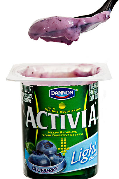 Activia By Dannon Chico, California, USA, - March 07,2011 : A spoon removing a bite of Dannons\' blueberry flavored Activia light from a green 4 OZ plastic container. Activia regulates the digestive system via the Bifidobacterium Lactis microorganism, which is also referred to by Dannon as Bifidus Regularis. Activia is a product of Dannon, one of the world leading yogurt producers. Activia Yogurt stock pictures, royalty-free photos & images