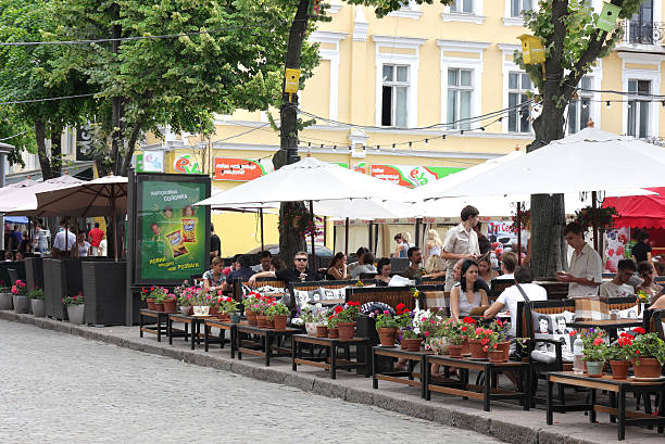 Outdoor dining "Odessa, Ukraine - August, 14, 2011: People relaxing at an outdoor cafe in the summer day . Photographed on Deribasovskaya, the main street of city." odessa ukraine stock pictures, royalty-free photos & images