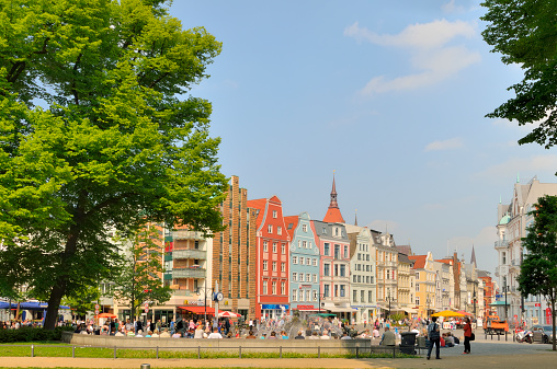 Rostock,Germany - May 21, 2011: Groups of people gather on the Rostock University Square enjoying a fine spring day. Looking down Kropliner Street, the old buildings in their pastel coloring indicate the history of the old Hanseatic city while the McDonalds offers a reality dose lest you think you\\'re in medieval times. You would never guess that a few years ago this was part of Communist East Germany.