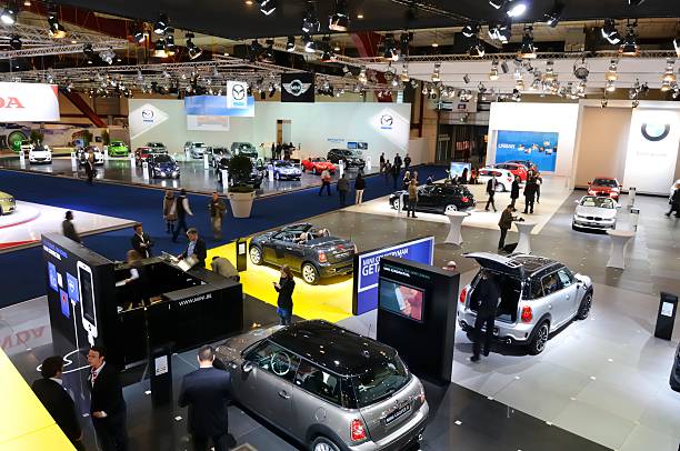 Brussels, Belgium - January 10, 2012: Mini, BMW and Mazda stand during the Brussels motor show. People in the background are looking at the cars.