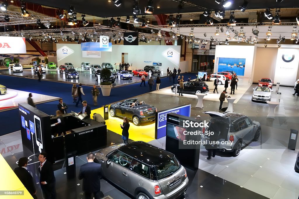 Mini, BMW and Mazda motor show Brussels, Belgium - January 10, 2012: Mini, BMW and Mazda stand during the Brussels motor show. People in the background are looking at the cars. BMW Stock Photo