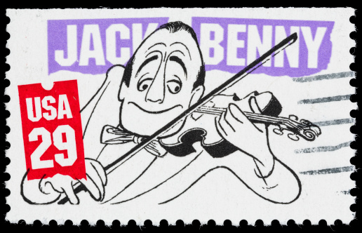 Sacramento, California, USA - June 8, 2012: A 1991 USA postage stamp with an illustration by Al Hirshfield of Jack Benny (1894-1974). Benny's onstage persona was that of an extreme miser, never aging beyond 39 years old, and playing the violen poorly.
