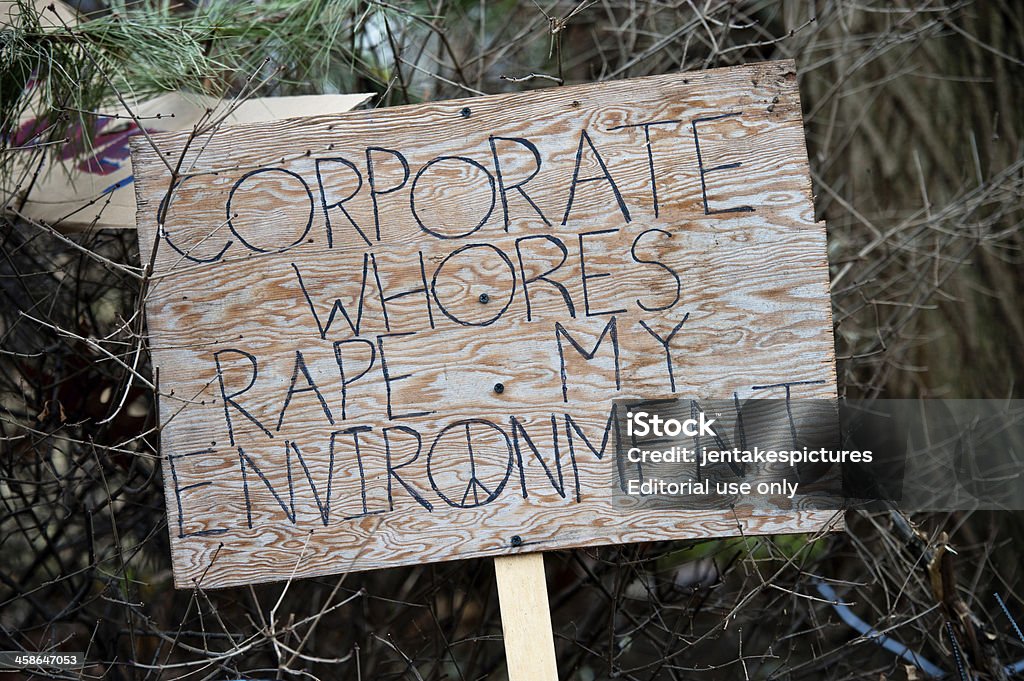 Protest Sign "Toronto, Canada - November 20, 2011: Close up of a protest sign in St. James Park on the 37th day of Occupy Toronto, a Canadian division of the international Occupy movement that began in New York as Occupy Wall Street.  The sign reads ""corporate whores rape my environment""." Anger Stock Photo
