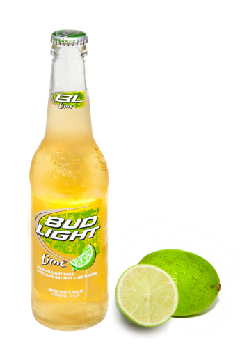 Nashville, Tennessee, USA - June 26th, 2011: A close up photo of a Bud Light Lime beer bottle, Budweiser\\'s sweet summer beer, isolated on white and brightly illuminated with a full lime and a lime cut in half sitting beside it.