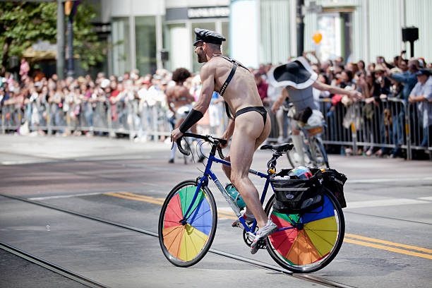 San Francisco, California, USA - June 26, 2011: At the annual S.F. Gay Pride Parade a man rides a bicycle with rainbow colored wheels up Market Street.  Considered to be one of the largest and most well-known Pride events in the world, this year's parade was the 41st and featured more than 200 floats and19 stages scattered around the city.