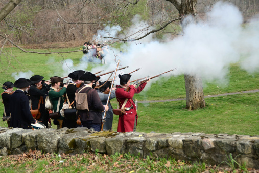 Lexington, Massachusetts, USA - April 14, 2012: Men dressed as American colonial militiamen or minutemen reenact one of the first battles of the American revolution as part of the annual Patriot's Day celebration.