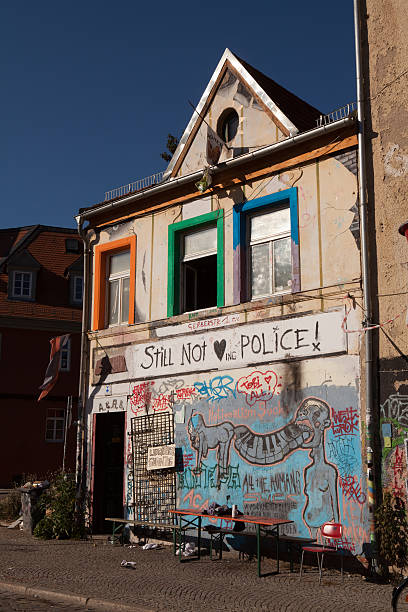 The brick wall of the old house is partially dismantled against the background of the blue sky. Dismantling the city's housing stock for renovation