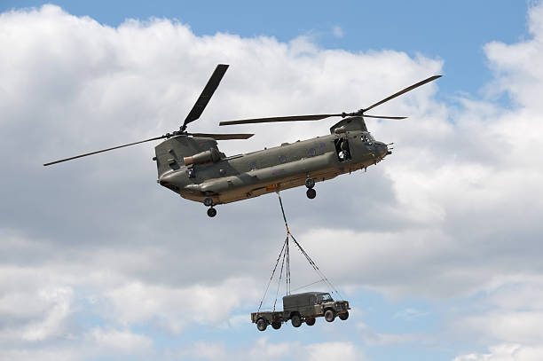 chinook helicopter "Farnborough, United Kingdom - July 24, 2010: British military Chinook transport helicopter giving a cargo carrying demonstration at the Farnborough International Airshow, 2010." chinook helicopter transporting car stock pictures, royalty-free photos & images