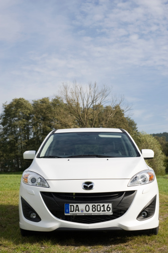 Moemlingen, Germany - October 18, 2011: Mazda 5 sits in a meadow. The Mazda 5 is MPV a multipurpose vehicle of the second generation.  This ist the 2011 model with a 1,6 liter diesel engine and 115 PS. Mazda is a Japanese automotive manufacturer founded in 1928. Mazda is headquatrered in Fuchu.