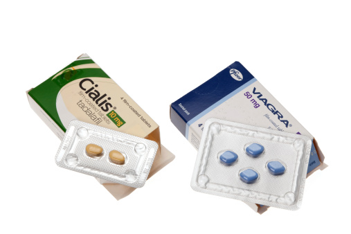 Folkestone, United Kingdom - May 6, 2011: Viagra and Cialis - Erectile dysfunction tablets.  A box of each tablets opened and displaying the contents.  A white background was used to isolate the subjects.