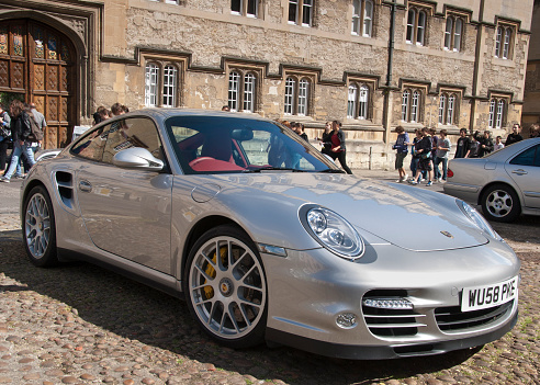 Oxford, England - May 8, 2011: Porsche 911 parked outside Oxford University building, students walking in the background.