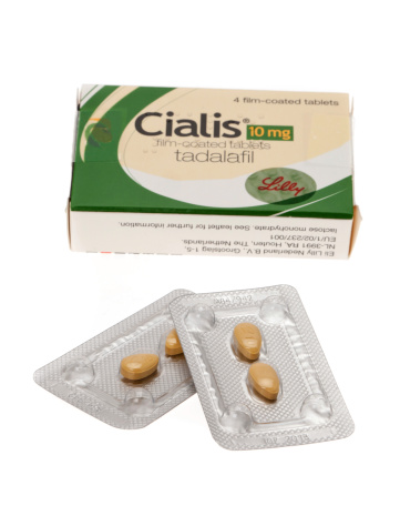 Folkestone, United Kingdom - May 6, 2011: Cialis tablets used to treat men suffering from erectile dysfunction.  A shallow depth of field was used with the focus sharp on the packs of tablets.