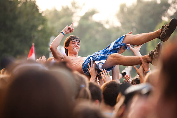 Sziget Music Festival Budapest Hungary Budapest, Hungary - August 15, 2010: A guy doing crowdsurfing during a concert in the main stage area of the Sziget Festival. The Sziget is one of the most important music and arts festival in the world. It takes place every august in Obuda island, close to Budapest. mosh pit stock pictures, royalty-free photos & images
