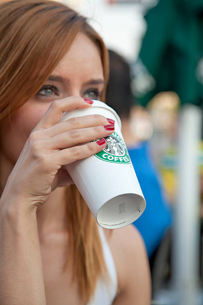 かわいい女の子の starbucks （スターバックス）コーヒーを飲む - starbucks coffee drink coffee cup ストックフォトと画像