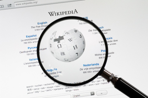 Utrechyt, The Netherlands - June 12, 2011: A magnifying glass on the start page of Wikipedia. Wikipedia is a online free encyclopedia to which volunteers can add articles.