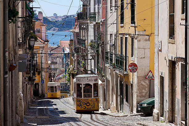 Lisbon, Portugal - 10 7 2022: typical old yellow vintage tram on the streets of Lisbon old town making its way through the narrow streets.