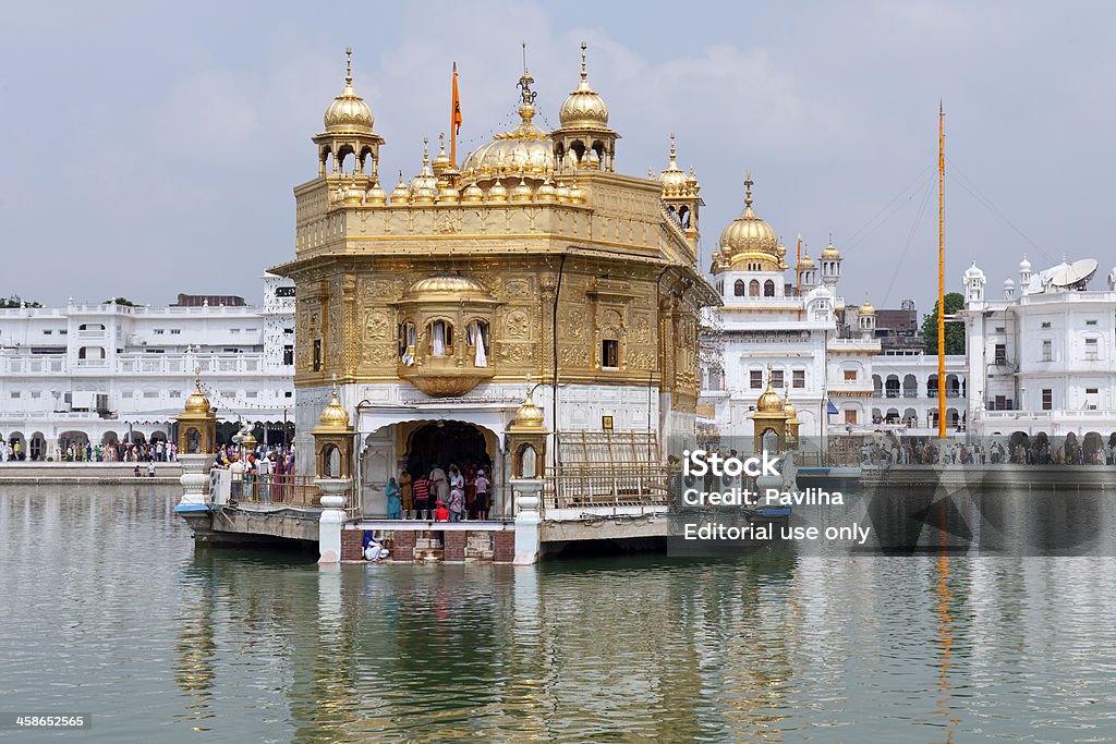 Golden temple Reflecting in Water Amritsar Amritsar, Punjab, India - July 10th, 2011: The Sikh holy temple The Harmandir Sahib is visited by pilgrims day and night. It is also considered to be one of the most beautiful tourist sites in India. Architecture Stock Photo