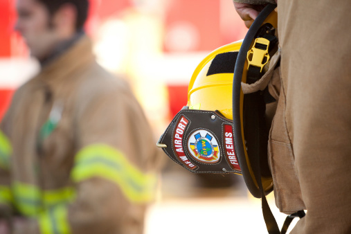 Fort Worth, TX, USA - April, 26 2010: Firefighter from DFW Airport holding his helmet at side during fire training exercise at the Tarrant County College Fire Academy training facility. This training Center will trains about 200 firefighters from 25 to 30 paid and volunteer fire departments in cities and industries in the North Central Texas Region.