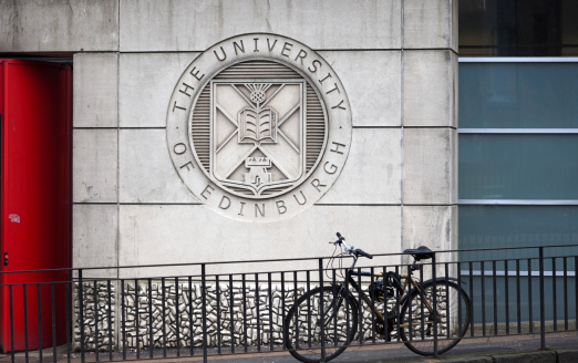 Edinburgh, Scotland, UK - February 22th 2011: Seal of the University of Edinburgh in the facade of the building. Bicycle parked in front.