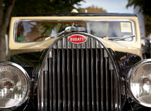 West Sussex, England - September 16, 2011: The radiator grill of a vintage Bugatti at the Goodwood Revival. Car manufacturer Bugatti was founded in Molsheim, Alsace, France by Italian-born Ettore Bugatti in 1909. Famed for their elegant designs and a large number of race wins, Bugatti produced a limited number of cars up to the 1950s. The name is now owned by the Volkswagon Group, which has resumed production of exclusive sports cars.