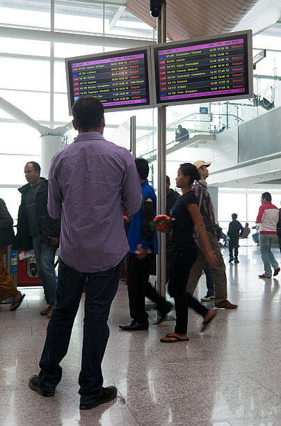 homme à la recherche de départ à repasser - airport india arrival departure board delhi photos et images de collection