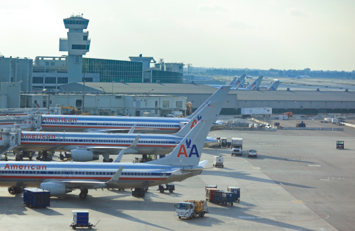 Miami, USA - February 20, 2011: American Airlines aircrafts in the airline hub terminal at Miami International Airport, surrounded by various support vehicles. AA have an important hub at Miami Airport were it connects to several domestic and international destinations.