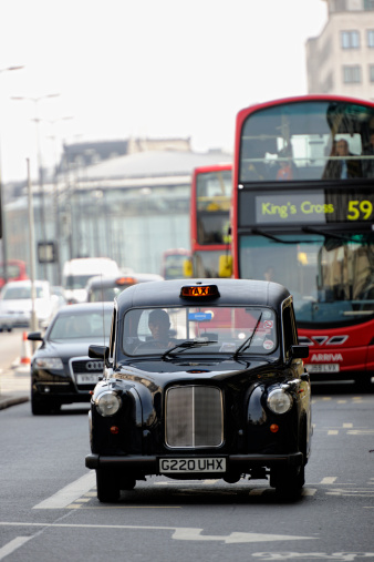 London, United Kingdom - May 6, 2011: A so-called Hackney Carriage is crossing Waterloo Bridge towards The Strand. The signage of the car is illuminated meaning the cab is available for hire. There are more than 20,000 of those cabs offering their service in London.