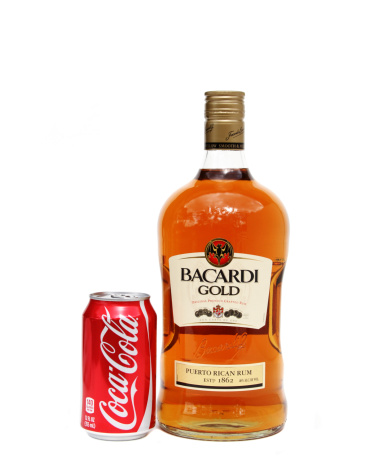 West Palm Beach, USA - February 16, 2011: A bottle of Bacardi Gold rum with a can of Coca Cola. The rum is a product of Puerto Rico, manufactured by the Bacardi Company Inc. Coca Cola is manufactured by the Coca Cola Company. Rum and coke is a popular combination for mixing together.