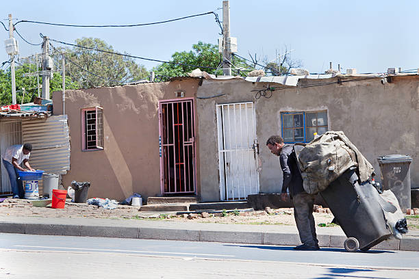 Pulling his cart off to the recycling plant Alexandra, South Africa - November, 5th 2011: An African man seen here carting his plastic goods to the recycling plant. Background urban living in Alexandra township. alexandra township photos stock pictures, royalty-free photos & images
