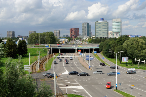 Utrecht, the Netherlands - August 8, 2011: View at highway and skyline in the south of Utrecht. At the left are rails for the tram between Utrecht and Nieuwegein / IJsselstein.