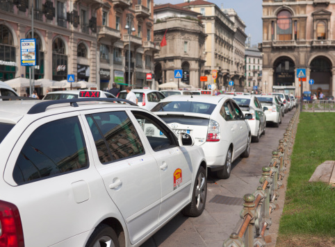 Milan, Italy - September 27, 2011: Row of white taxis in taxi stand in Piazza del Duomo.