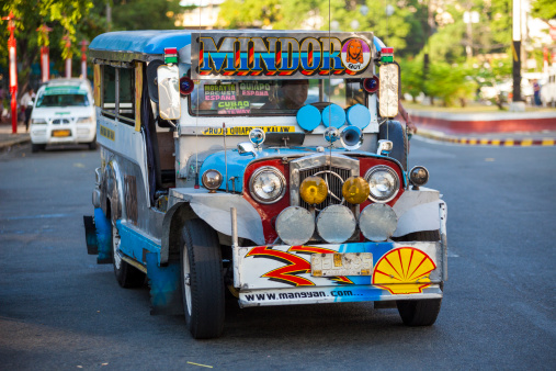 Manila, Philippines - April 19, 2012: Colourful Jeepney vehicle makes its way through traffic in Metro Manila.