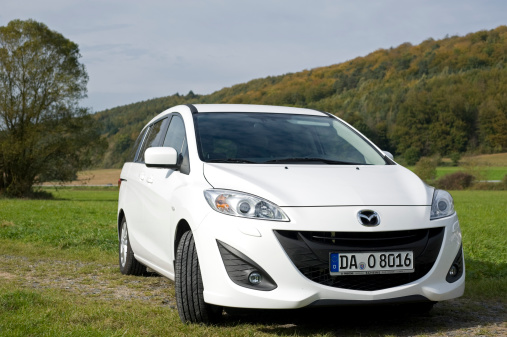 Moemlingen, Germany - October 18, 2011: Mazda 5 sits in a meadow. The Mazda 5 is MPV a multipurpose vehicle of the second generation.  This ist the 2011 model with a 1,6 liter diesel engine and 115 PS. Mazda is a Japanese automotive manufacturer founded in 1928. Mazda is headquartered in Fuchu.