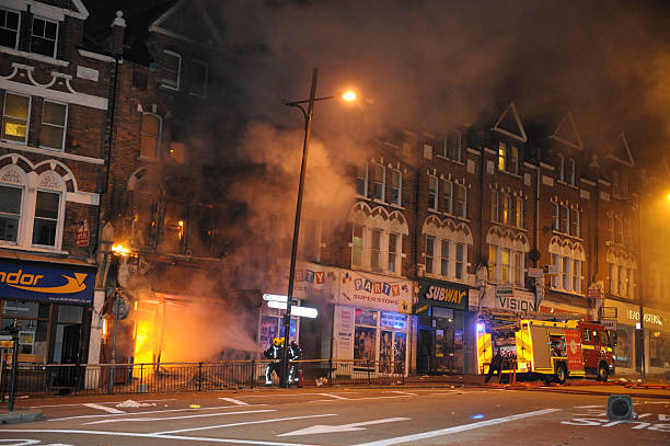 Firefighters douse fire after London riots London, England, United Kingdom - August 8, 2011: Firefighters tackle fire at Party Superstore on Lavender Hill, Clapham Junction after it was set alight by arsonists during London riots. wandsworth photos stock pictures, royalty-free photos & images