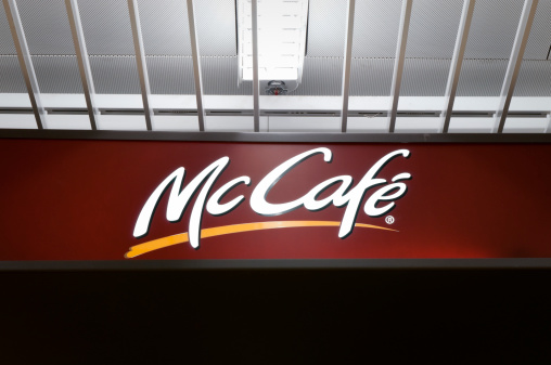 Frankfurt Airport, Germany - March 19, 2011: Illuminated sign of McDonald's McCaf&eacute; located in the shopping area of Frankfurt Airport. McDonald's introduced the food chain designed as coffee-house-style in Europe in order to keep up with other coffee house chains such as Costa Coffee and Starbucks Coffee. McCaf&eacute; is now a global brand after being introduced in 1993 in Australia. Frankfurt Airport services millions of passengers per year, constituting a prime location for McDonald's and McCaf&eacute; respectively.