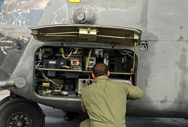 Engineer performs military elicopter maintenance stock photo