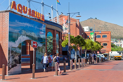 Cape Town, South Africa - December, 31st 2011: Entrance to Two Oceans Aquarium in Cape Town at the V & A Waterfront, with tourists standing below. Table Mountain seen in the background.