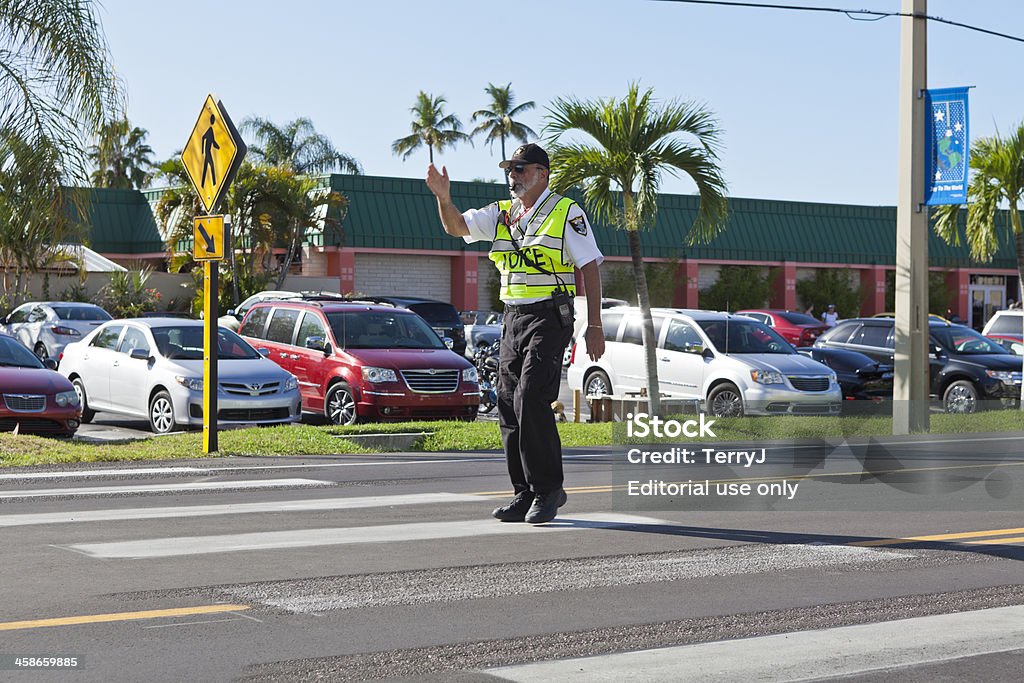 Directing Traffic Ft. Myers, Florida, USA - November 27, 2011:  A policeman directs traffic at a crosswalk during the 25th Annual World Championship Sand Sculpting Event held at Ft. Myers Beach in Florida. Traffic Warden Stock Photo