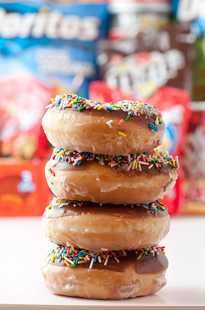 Unhealthy eating. Donuts with junk food in blurred background. stock photo