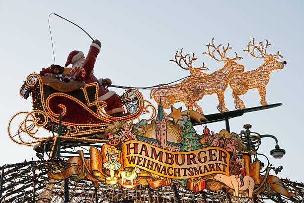 Hamburg, Germany - December 24th 2011: Scene from Hamburg\\'s Christmas market entrance in front of the Town hall. On the picture are illuminated deers and Santa Clause in chariot full of presents
