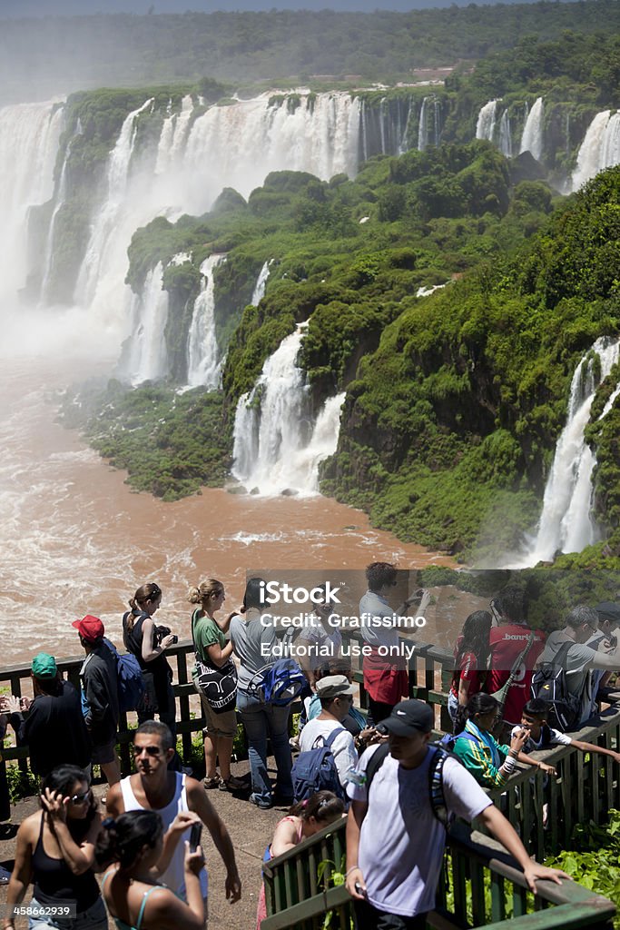 Gruppo di turisti scattare foto alle cascate di Iguacu in Brasile - Foto stock royalty-free di Ambientazione esterna