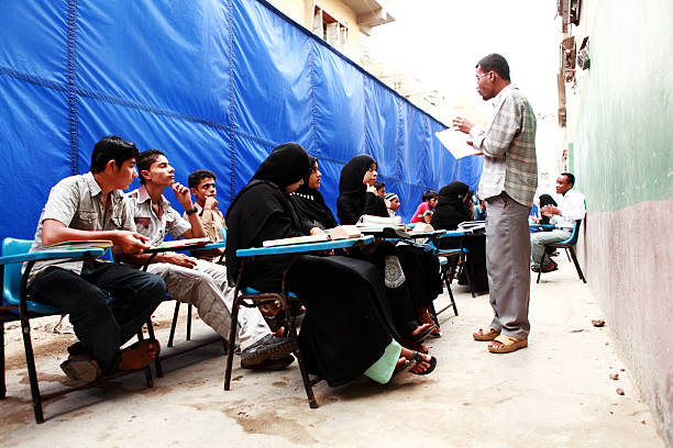 gli insegnanti di condurre lezioni in strada scuola eseguire per braccio - community outreach social worker teenager poverty foto e immagini stock