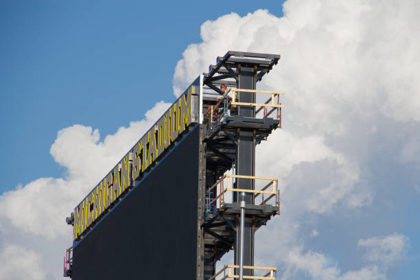 Michigan Stadium's New Scoreboard Ann Arbor, Michigan, USA - July 30, 2011: A worker takes a moment to appreciate the view from atop the Michigan Stadium video scoreboard, which is under construction. michigan football stock pictures, royalty-free photos & images