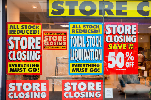 Brighton, United Kingdom - July 7, 2011: View of a diplay window of a furniture store with posters of total stock liquidation and big discounts due the imminent closure